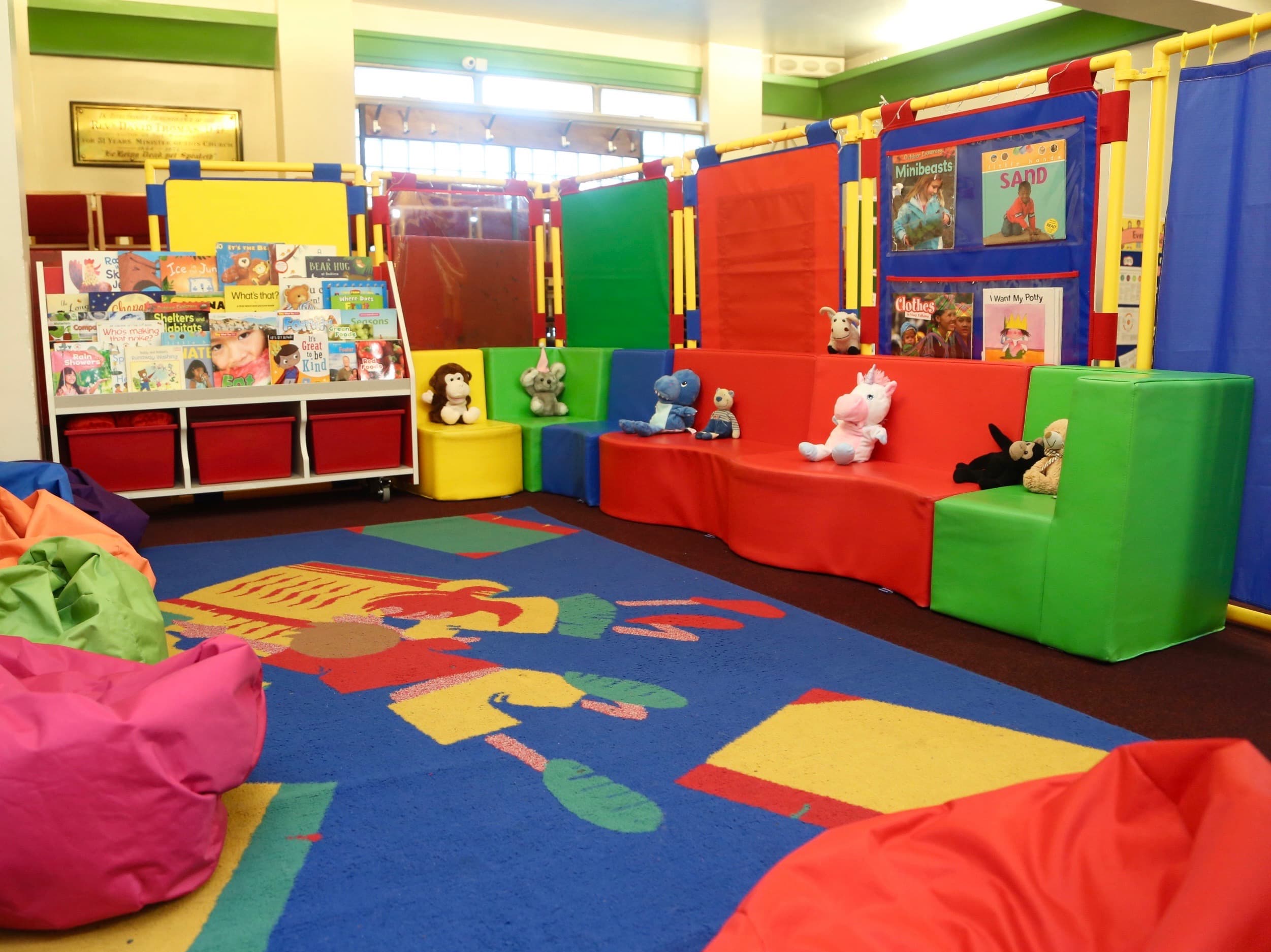 Cosy reading corner with colourful sofas and book rack